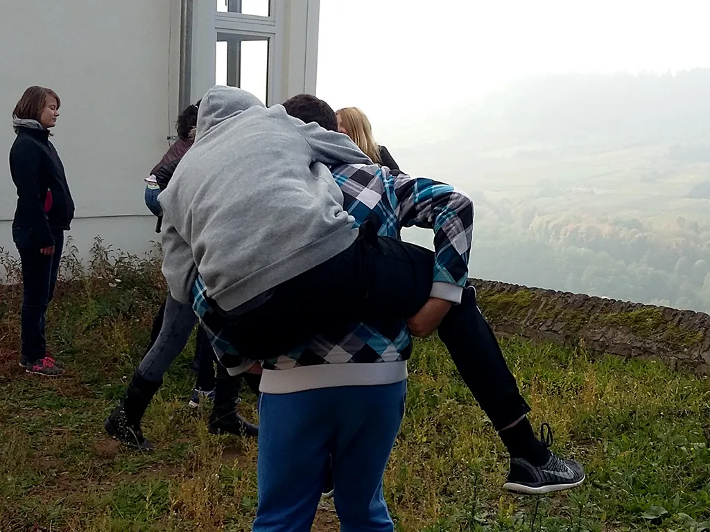 Jugendliche tragen sich gegenseitig auf dem Rücken.